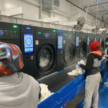 Industrial washer extractor with digital control panel in commercial laundry facility