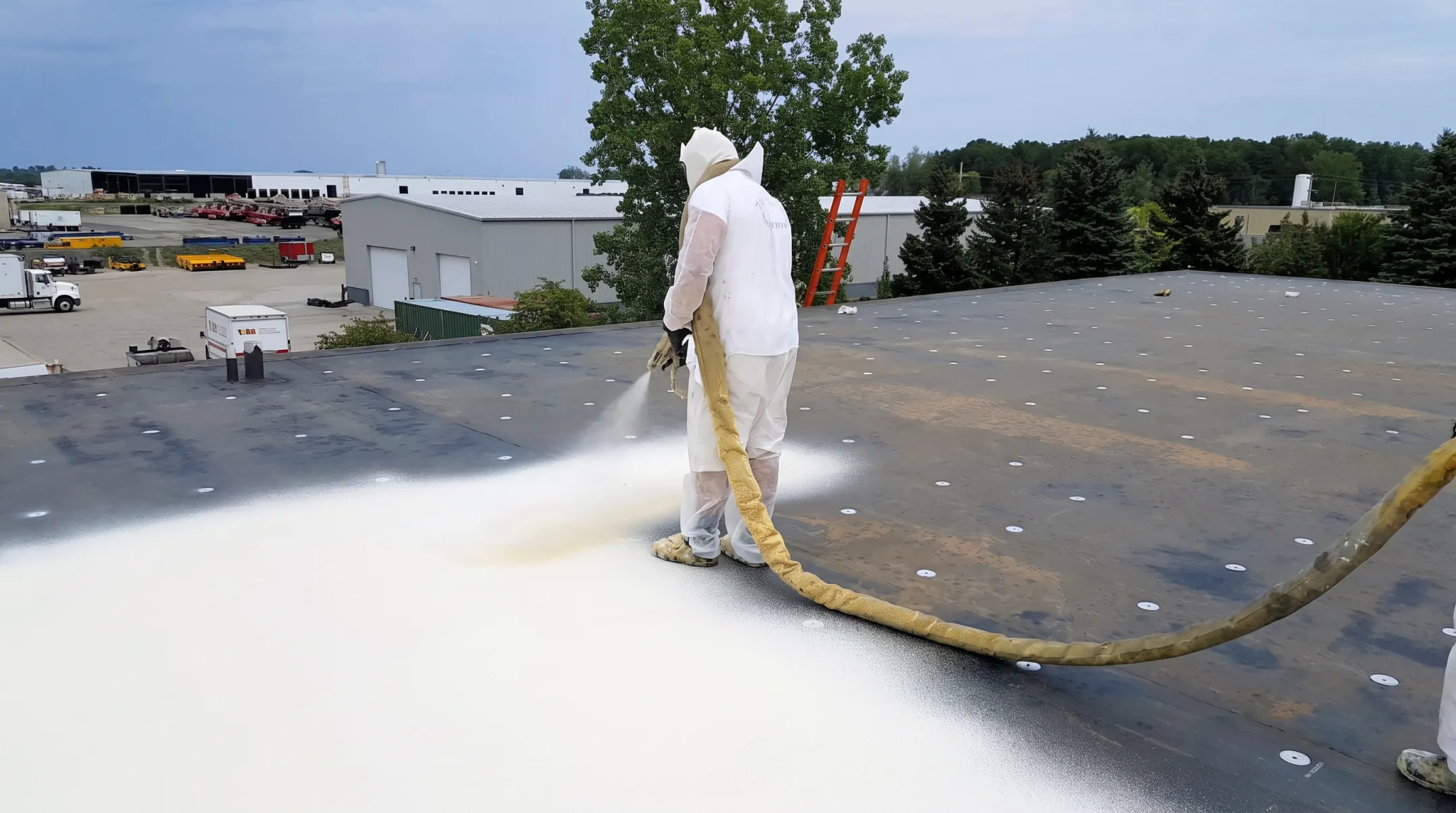 Professional crew applying silicone roof coating across commercial membrane