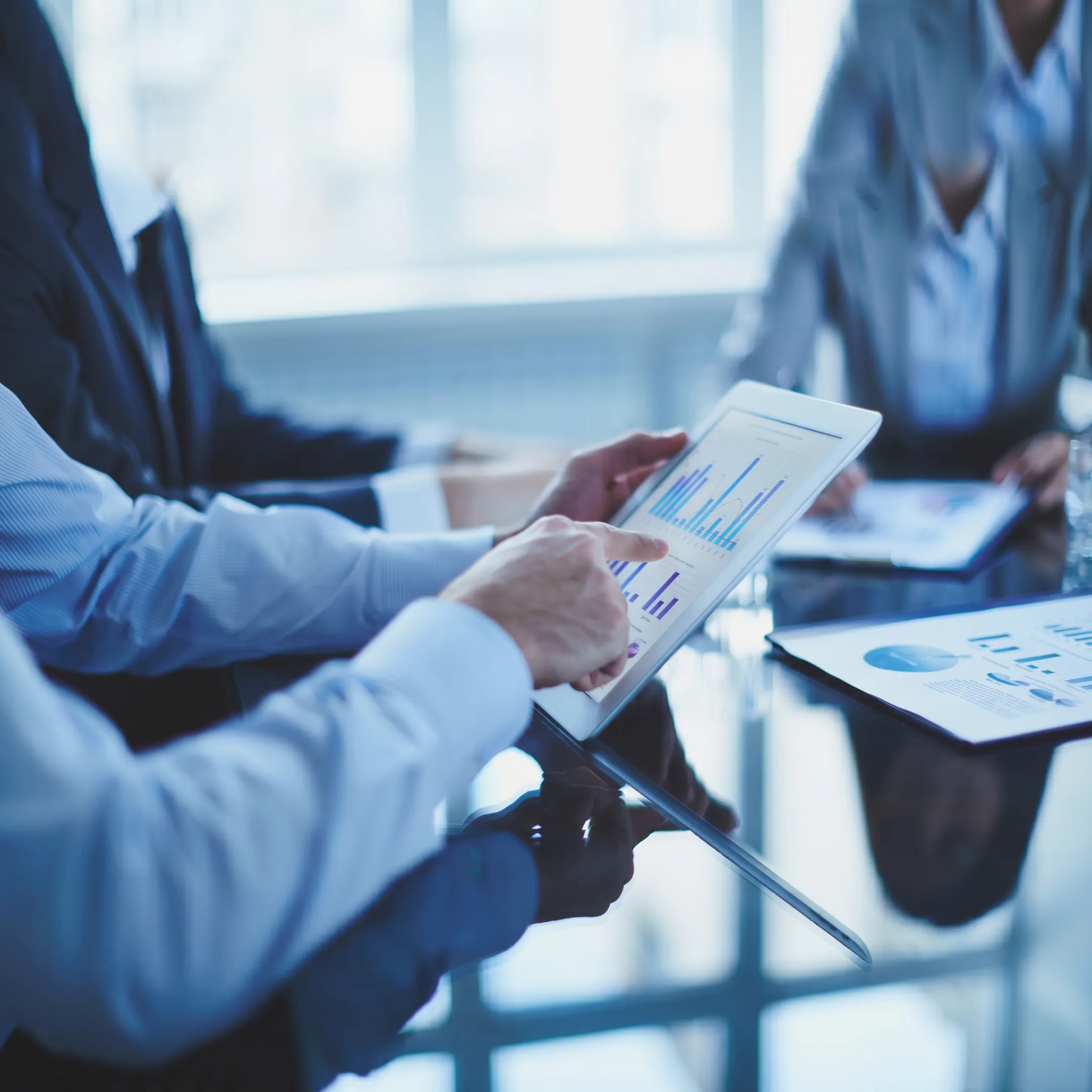 Cyber security consultants reviewing risk dashboards and compliance documentation with business leaders
