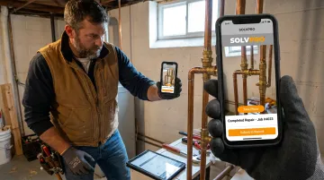 Plumbing technician using SolvPro mobile app to photograph completed job on-site