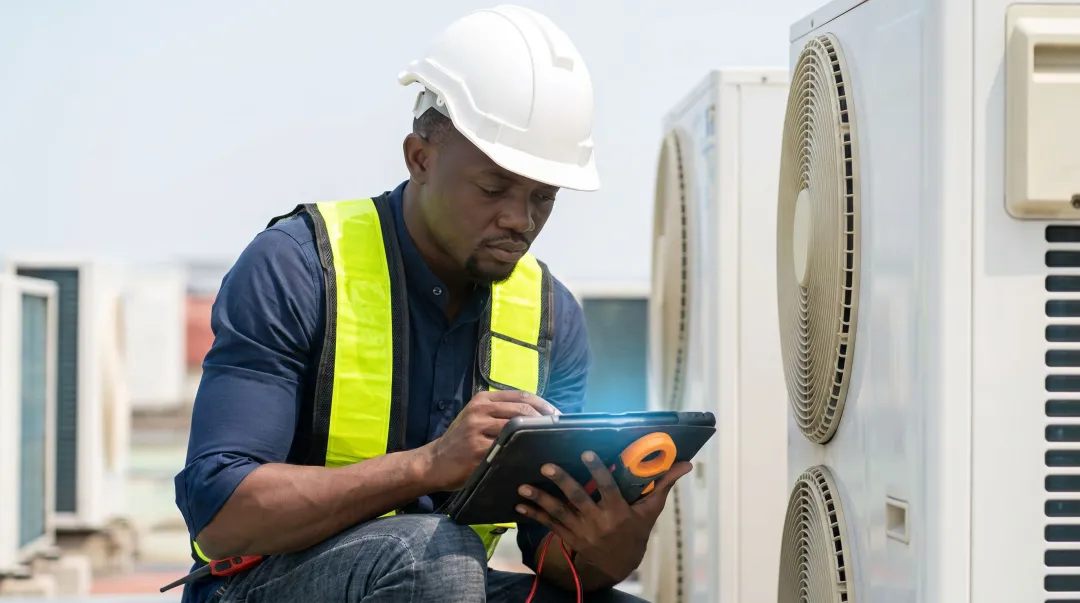 Field service technician using mobile app on job site to complete work order