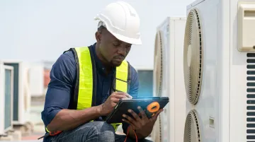 Field service technician using mobile app on job site to complete work order