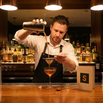 Bartender serving a drink in a bar, representing liquor liability insurance.