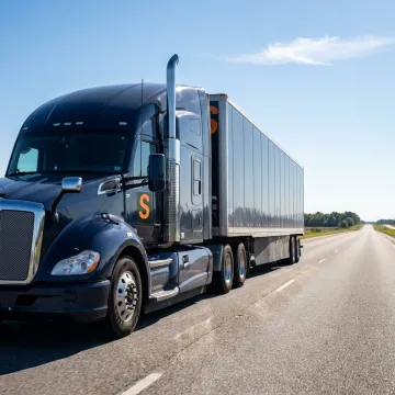 A semi-truck on a highway, representing the trucking industry for workers' compensation insurance.