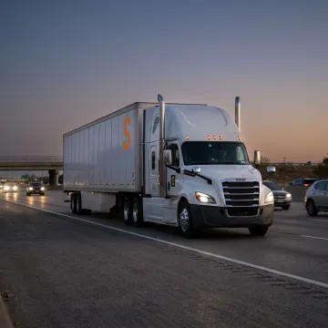 A semi-truck driving on a highway in Arlington, Texas, representing commercial truck insurance services.