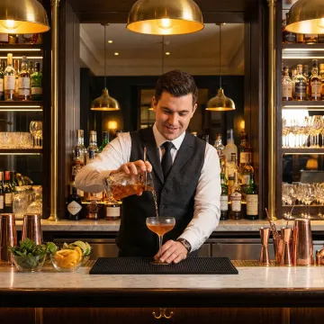 Bartender pouring drinks behind a bar counter with liquor liability insurance coverage