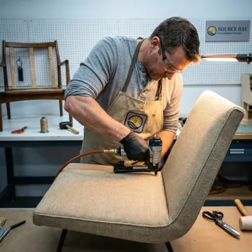 Craftsperson reupholstering a commercial lounge chair