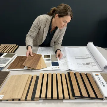 Designer reviewing wood panel finish samples