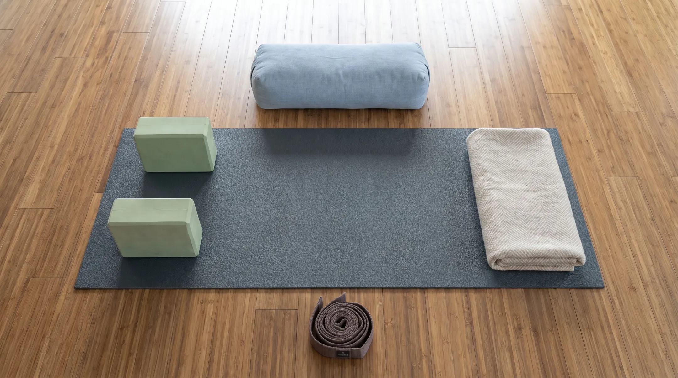 Beginner yoga essentials mat blocks strap and folded blanket arranged