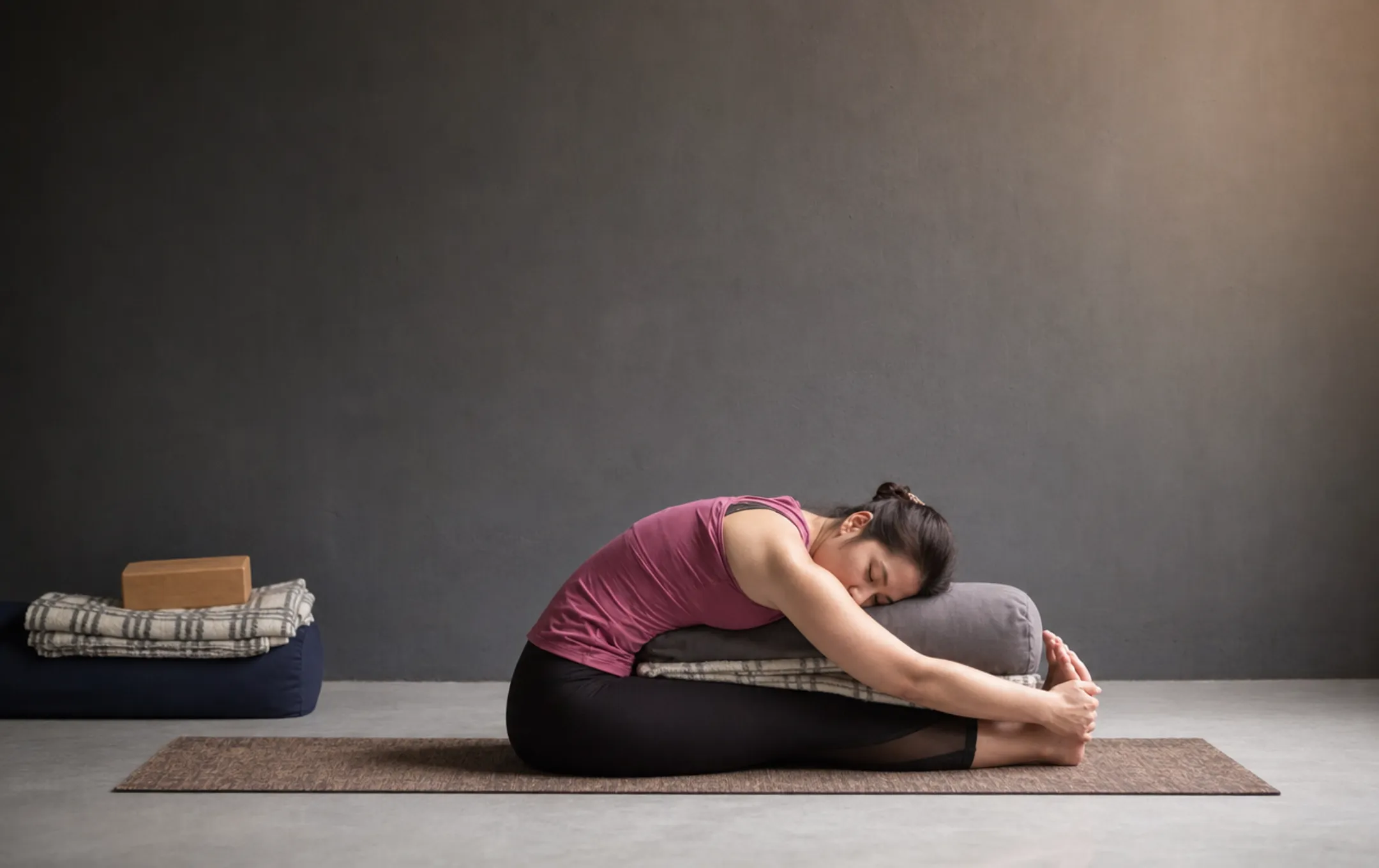 Person practicing seated Yin Yoga pose with props and calm breathing