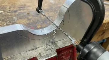 Spyral Saw 360-degree wire saw blade cutting contour on metal workpiece