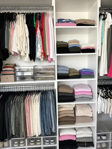 Organized walk-in closet with neatly arranged clothing and accessories