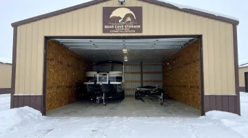 Bear Cave Storage enclosed indoor boat storage facility with overhead door and pontoon boat