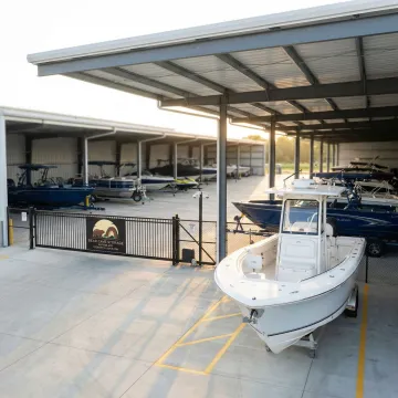 Secure boat storage facility with multiple watercraft stored under protective cover
