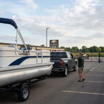 Boat owner parking a trailered boat in outdoor storage