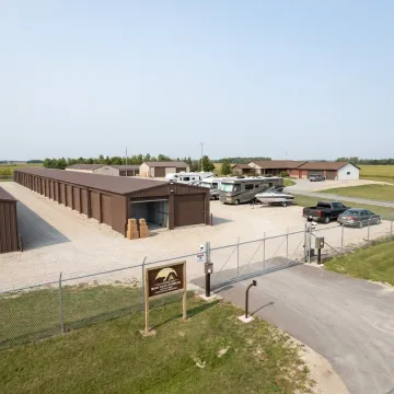 Secure Rochester storage facility with units and parked vehicles