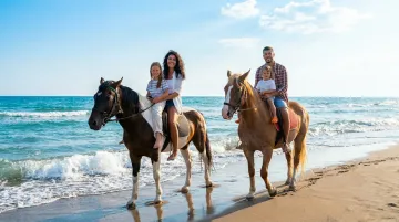 Family enjoying a scenic horseback ride on the sandy shores of Amelia Island