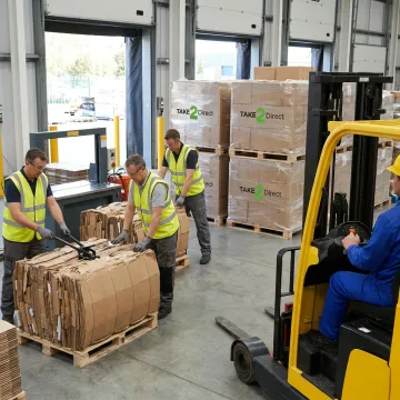 Warehouse team managing baled cardboard recycling