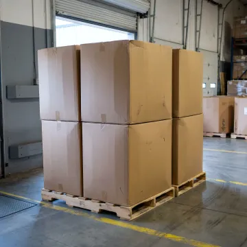 Warehouse team preparing stacked gaylord boxes for recycling pickup