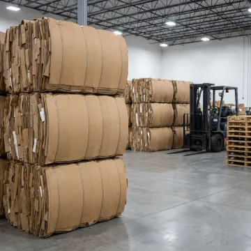Stacked OCC bales in warehouse recycling area