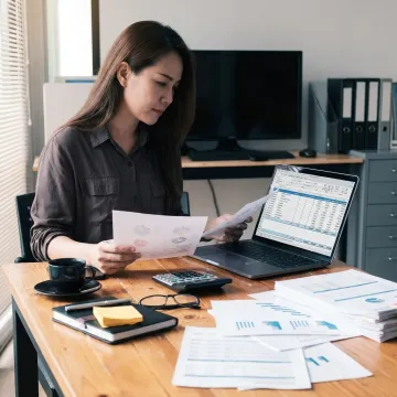 Payroll and bookkeeping professional working with financial reports