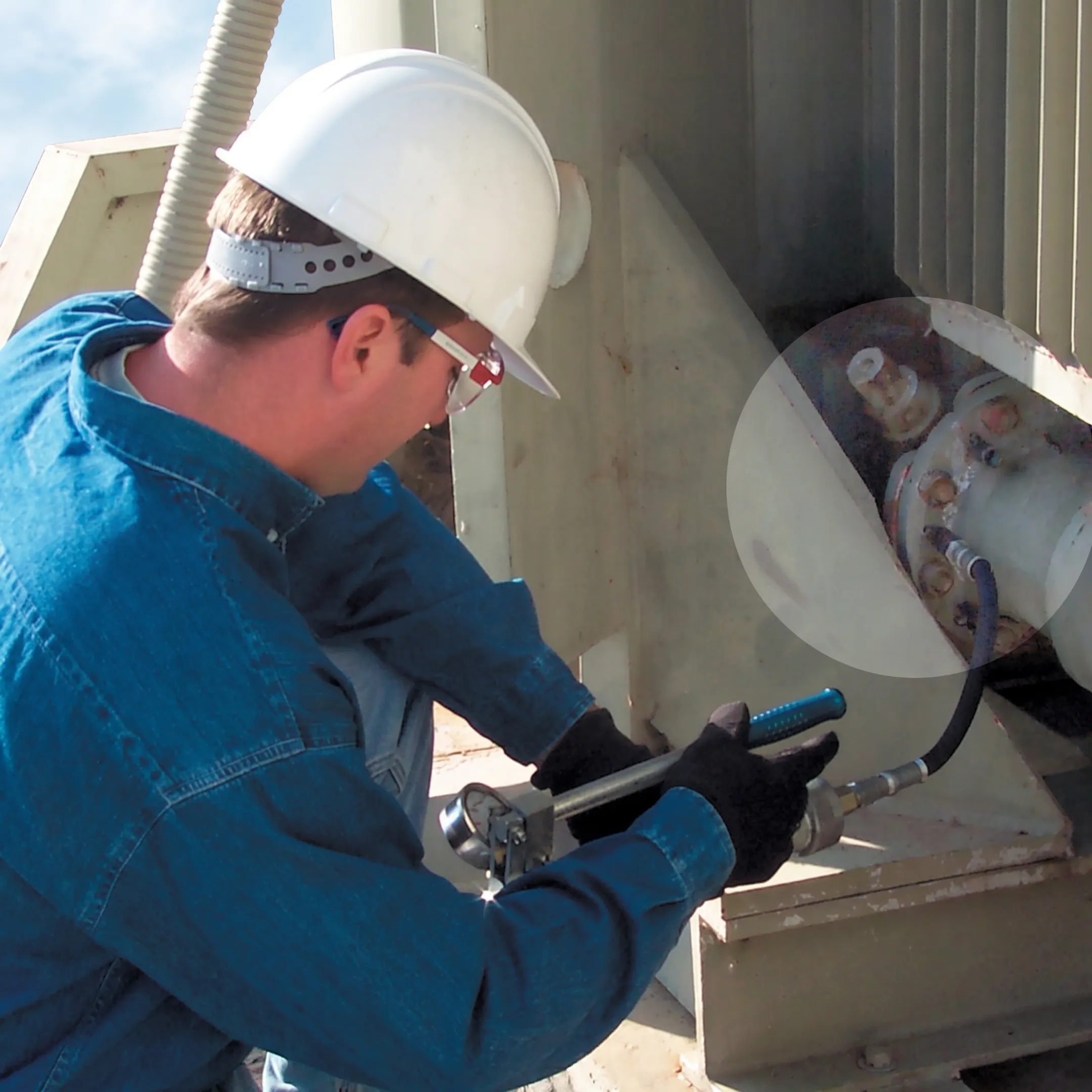 Technician sealing an oil leak on an energized transformer