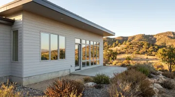 Fiber cement and stucco exterior wall cladding on WUI wildfire-resistant home construction