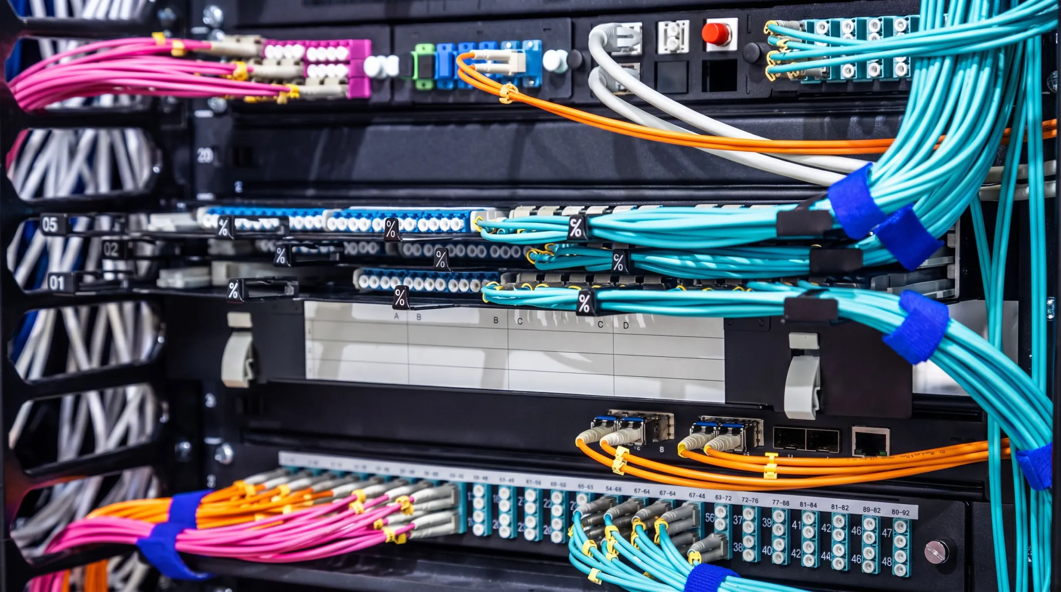 Fiber optic cables connecting data center network equipment racks