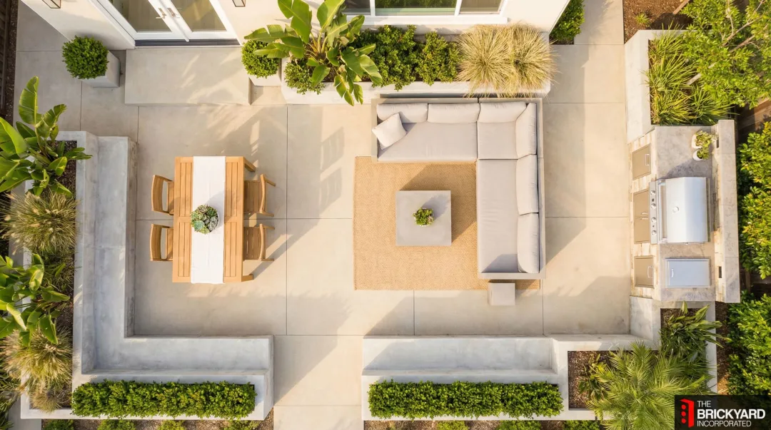 Concrete patio divided into three functional outdoor living zones with furniture and planters