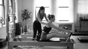 Pilates instructor cueing client alignment and breath coordination during private session