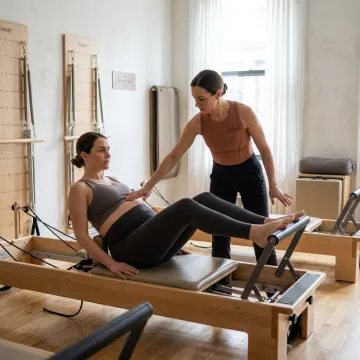 Pregnant client receiving Pilates instruction in a calm studio