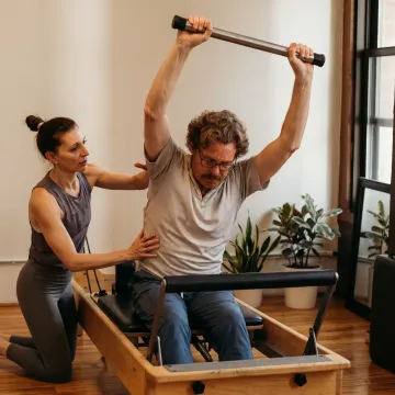 Client practicing Pilates on studio equipment