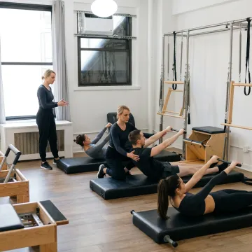Small group reformer Pilates class in a boutique studio