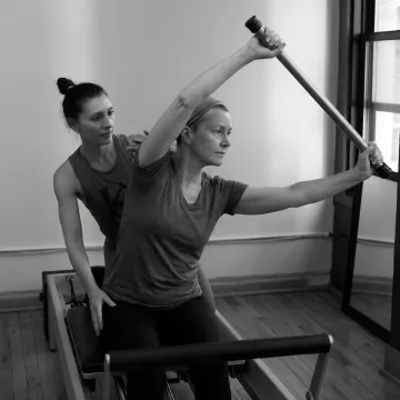 Breast cancer survivor receiving gentle Pilates instruction