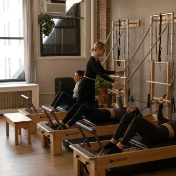 Pilates instructor guiding students in a boutique studio