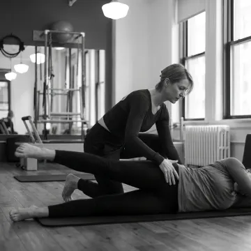 Instructor guiding a Pilates mat exercise