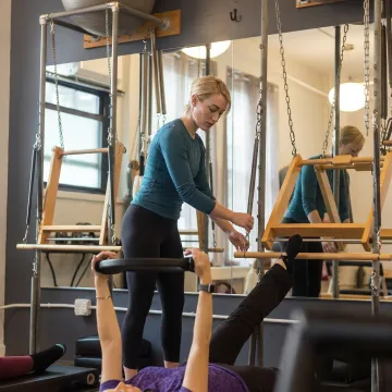 Instructor preparing reformer for private Pilates session