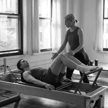 Client practicing Reformer Pilates in a Manhattan studio