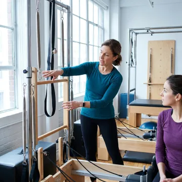 Instructor coaching Pilates tower technique