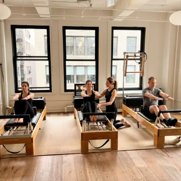 Intermediate Pilates reformer class in a boutique studio