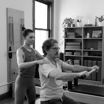 Client practicing Classical Pilates with instructor support