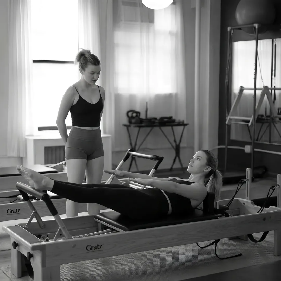 Pilates instructor guiding a beginner through Reformer basics