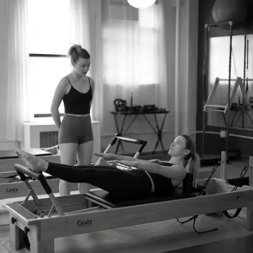 Pilates instructor guiding a beginner through Reformer basics