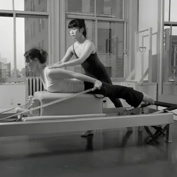 Pilates instructor guiding a client through rehabilitation exercises