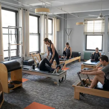 Instructor guiding small group Reformer strength training