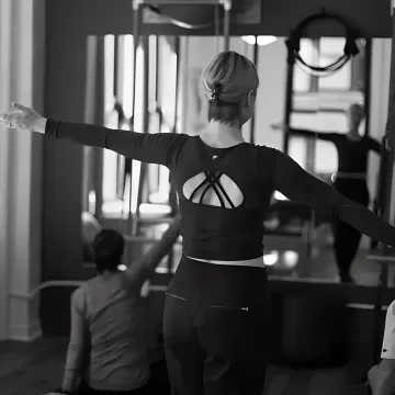 Instructor supporting gentle Pilates recovery work