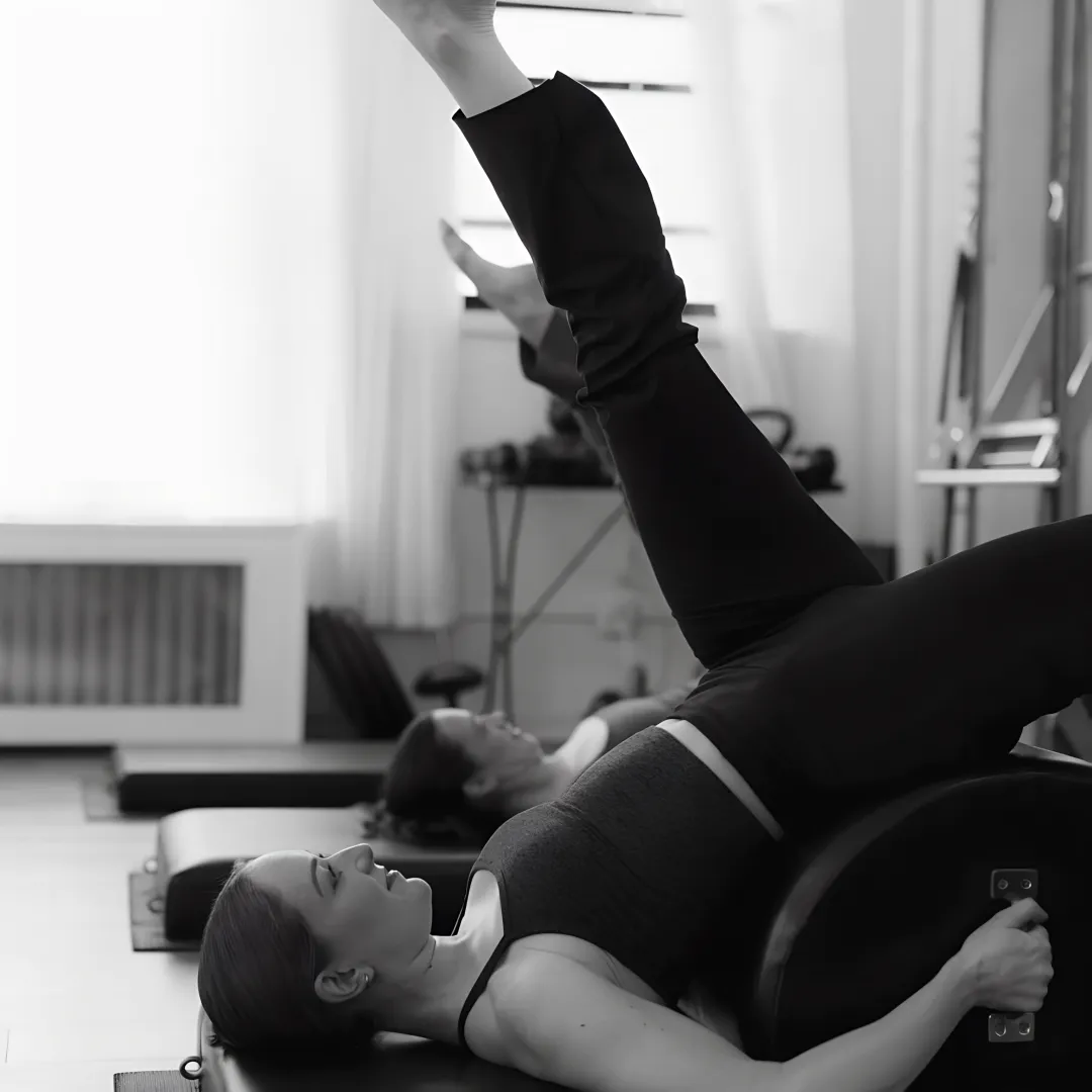 Instructor supervising bone-conscious Pilates strength training