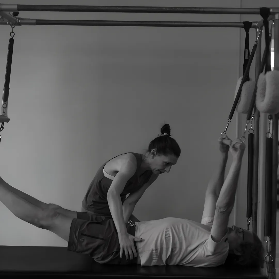 Pilates teacher guiding a private client through reformer exercises