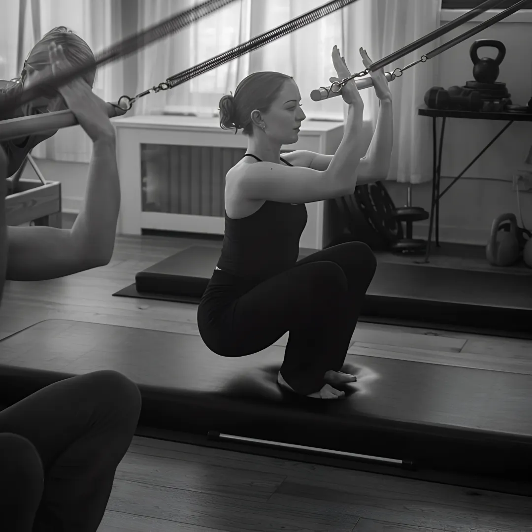 Pilates instructor correcting mat exercise form