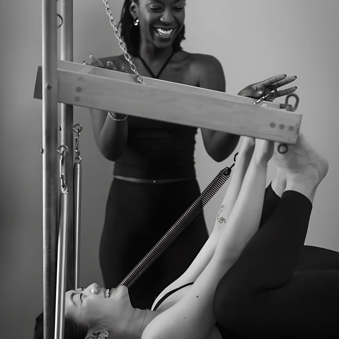 Private Pilates instructor guiding a client on reformer equipment
